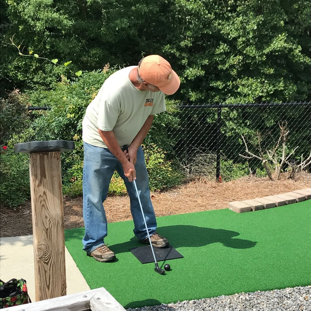 man playing mini golf